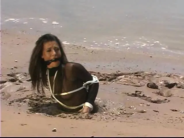 Nylon wearing babe escaped abduction but keeps getting stuck in wet sand