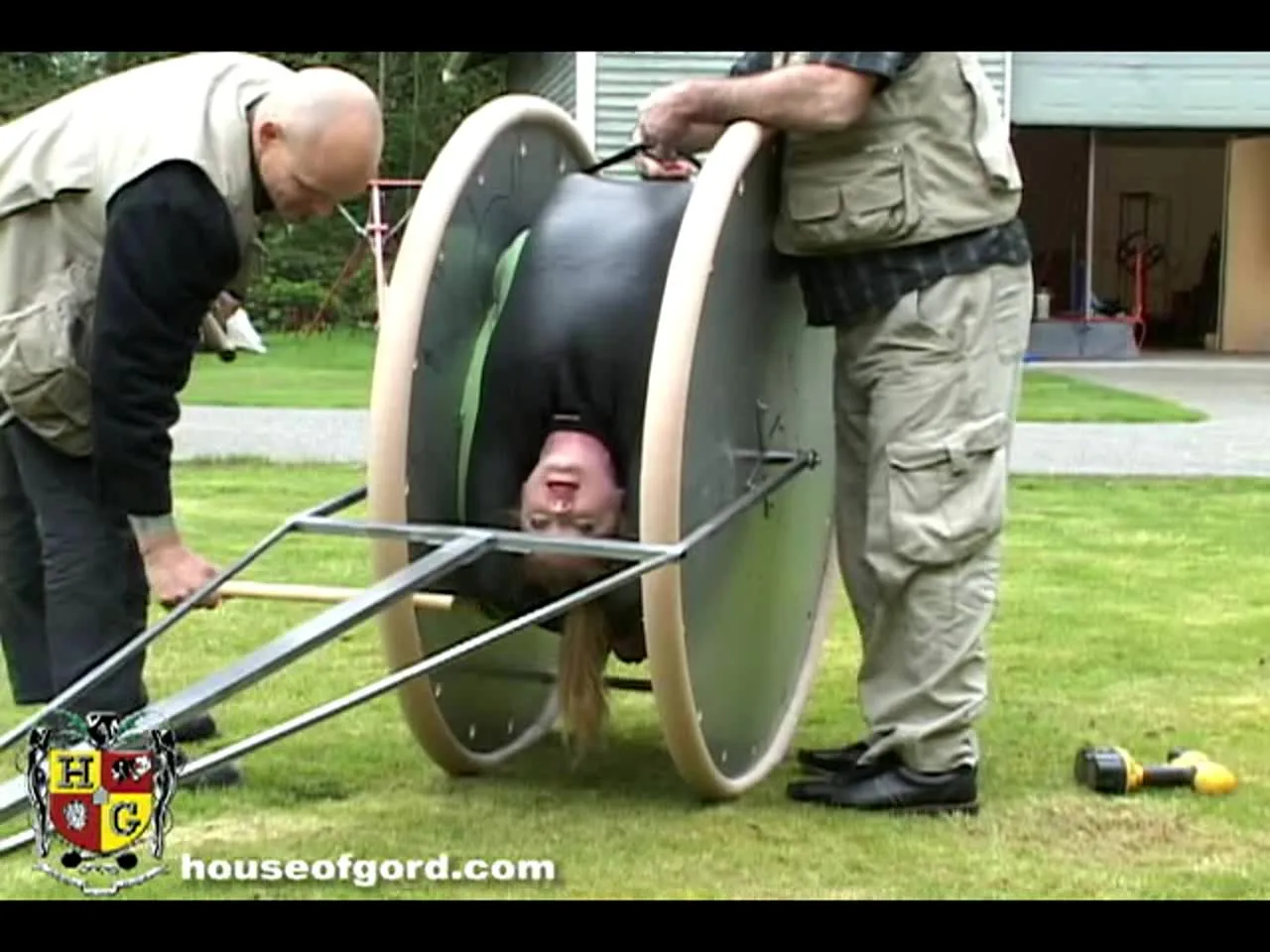 Slave bitch bent over a torture wheel and driven around the lawn