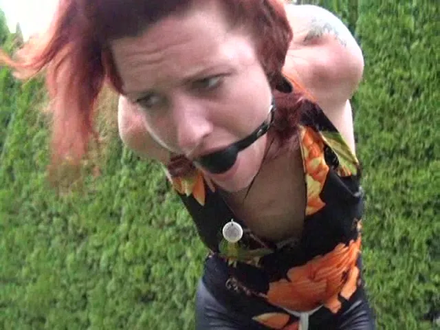 Ballgagged redhead shown completely helpless outdoors